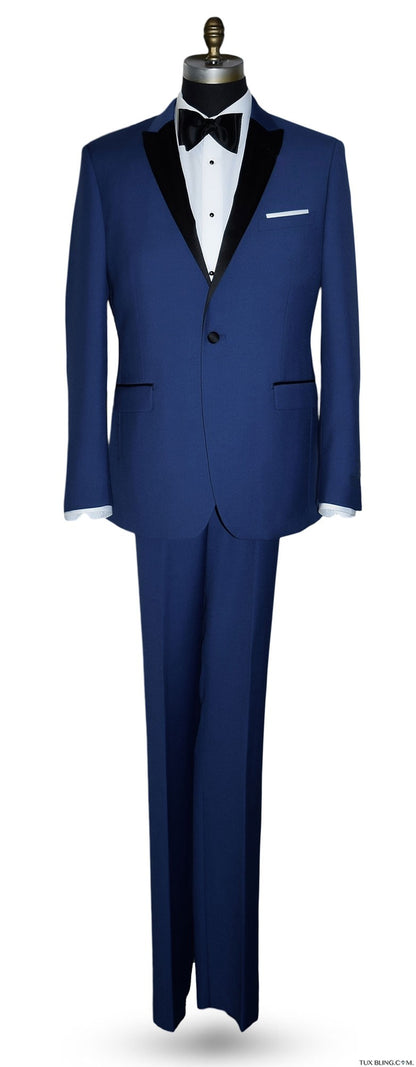 Mannequin wearing a royal-blue tuxedo with black peak lapel, royal blue trousers, and a black satin bowtie, against a white background.