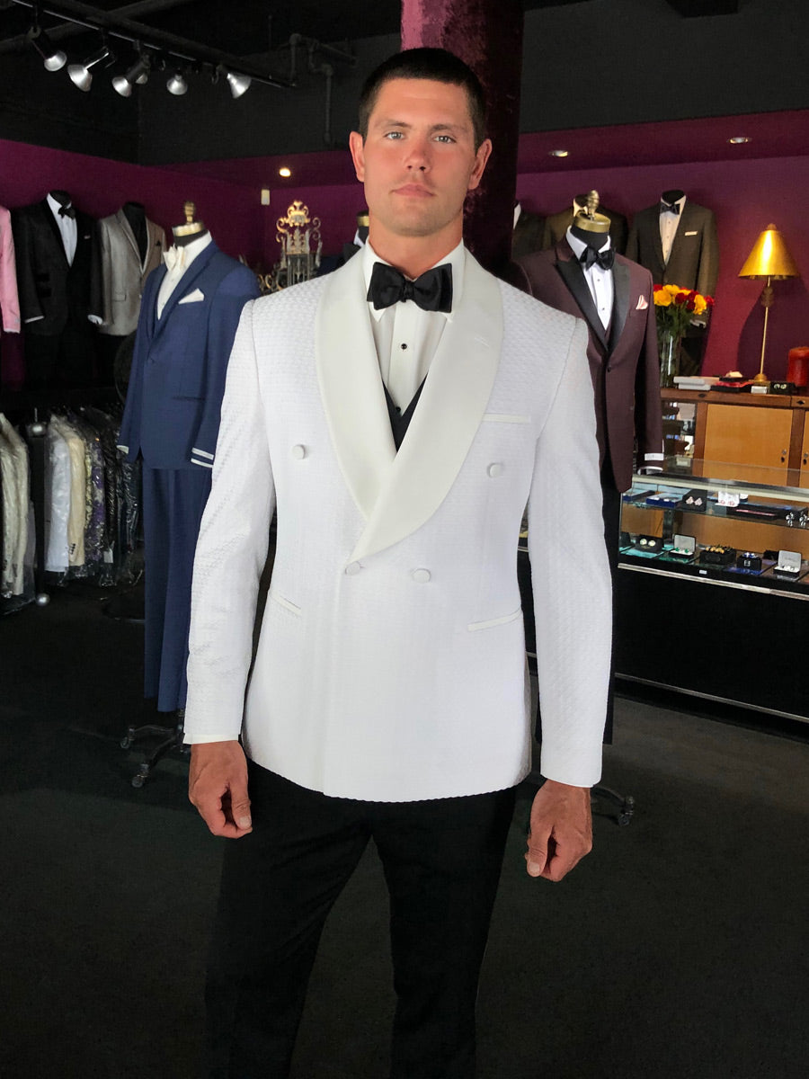 man wearing off-white double breasted tuxedo jacket with a black bow tie in a tuxedo shop