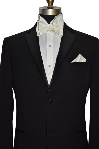 black tuxedo with a ivory shirt and off-white tuxedo vest and off-white "self-tie" bowtie and off-white pocket handkerchief against a white background