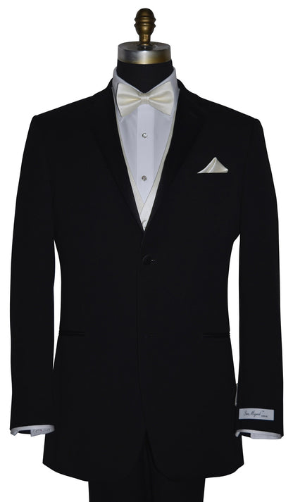 Black tuxedo with "San Miguel Especial" branded label on a mannequin with a white shirt and off-white tuxedo vest and off-white bow tie against a white background