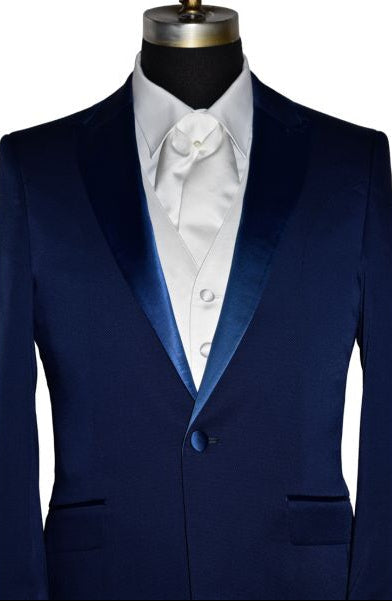 very close-up life size mannequin wearing a persian blue tuxedo with white satin vest and white satin ascot against a white background