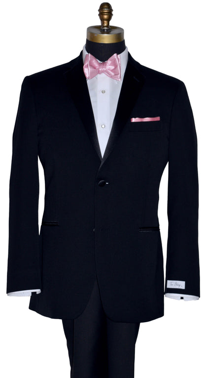 close-up black tuxedo wearing a white tuxedo shirt with a pink silk "tie-yourself" bowtie against a white background