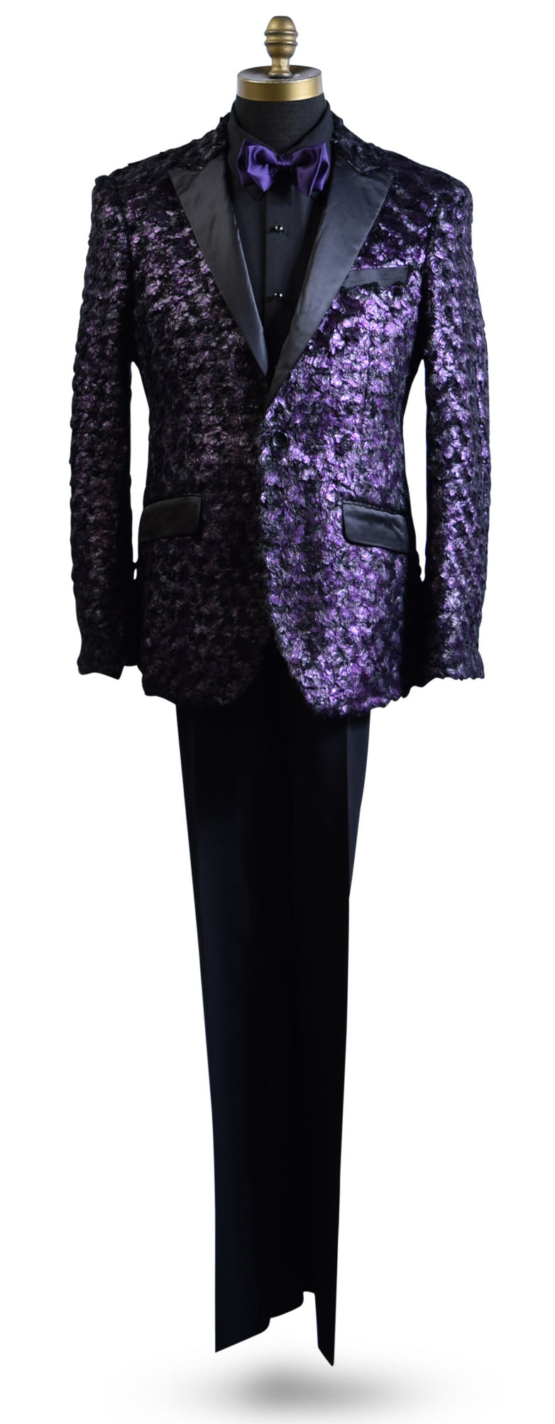 life size mannequin wearing a purple tuxedo with black lapels with a black tuxedo shirt and purple bowtie against a white background
