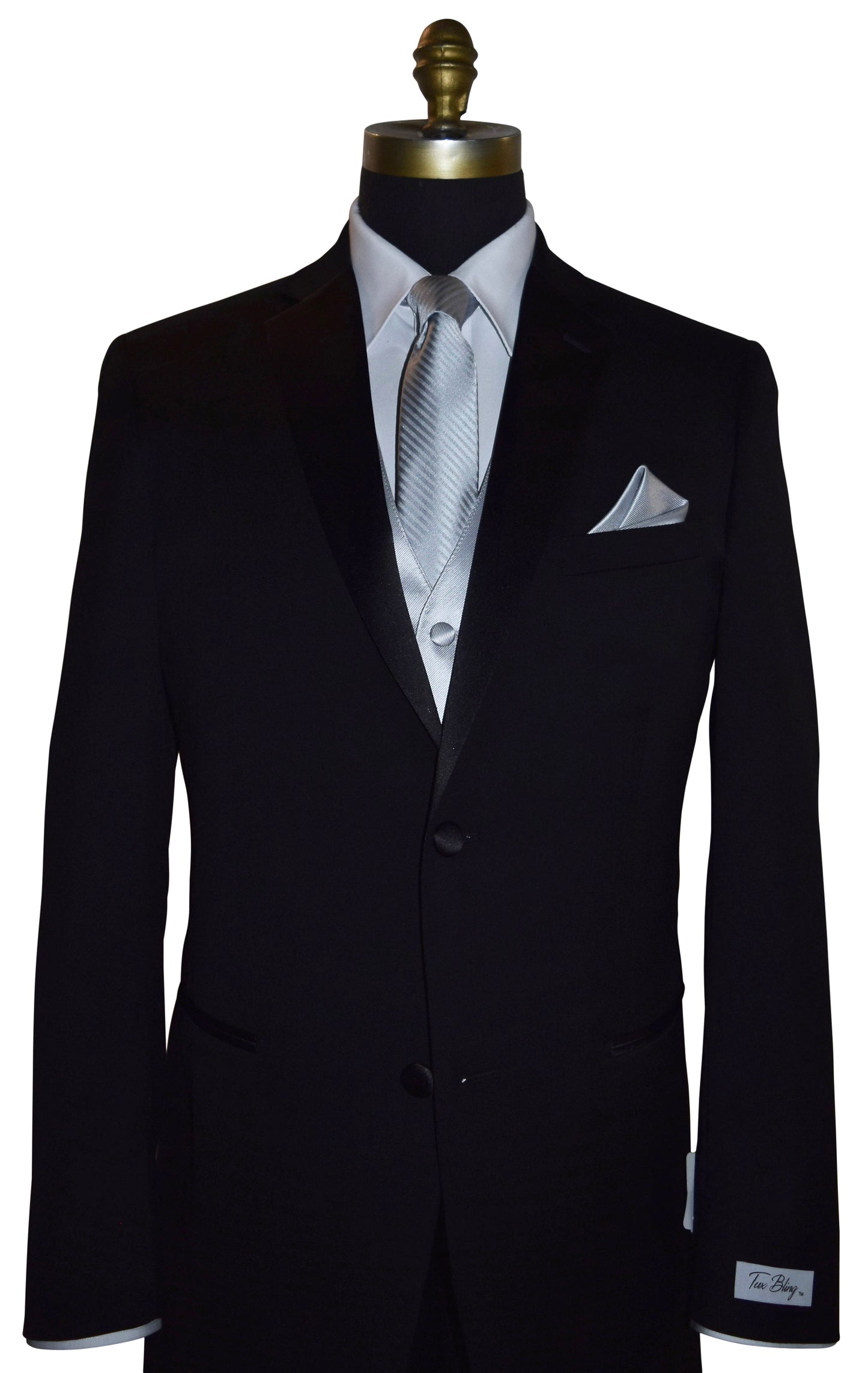Black wedding suit with a "Tux Bling" branded label on the sleeve on a mannequin with a white shirt, silver necktie and silver vest, and pocket square.