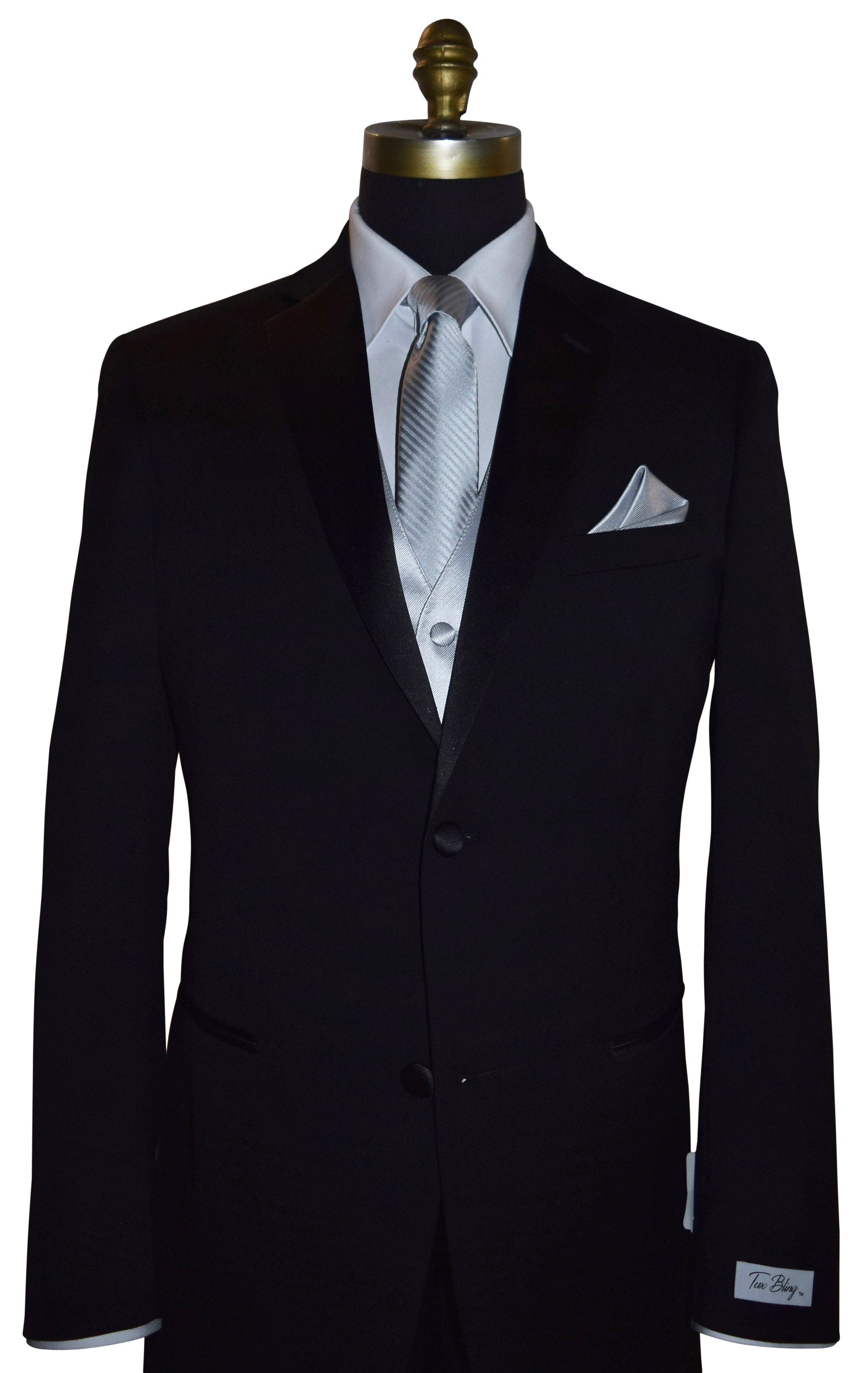 Black wedding suit with a "Tux Bling" branded label on the sleeve on a mannequin with a white shirt, silver necktie and silver vest, and pocket square.