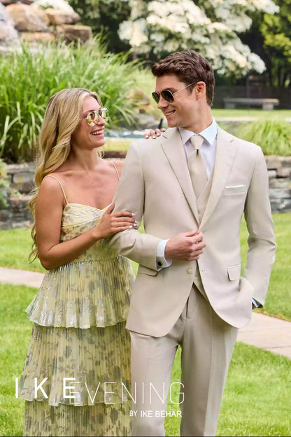 Front view of caucasian model wearing a slim fit suit with a female model while outdoors in a garden.