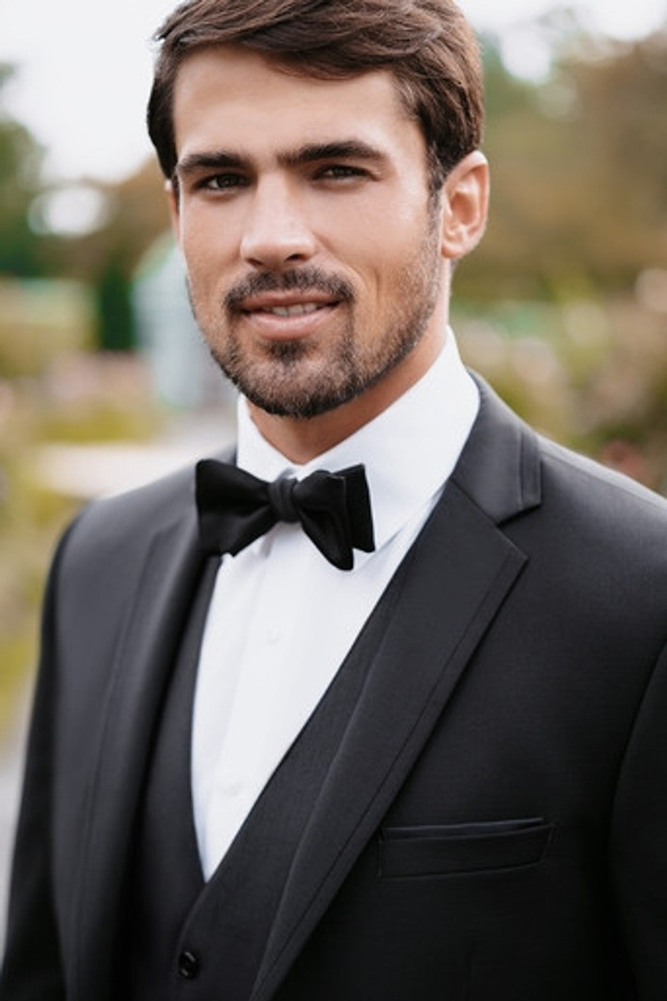 CLOSE up of man wearing a black slim-fit suit with black bowtie