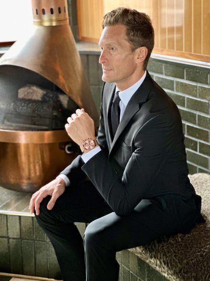 Man wearing black slim-fit suit at a restaurant.  