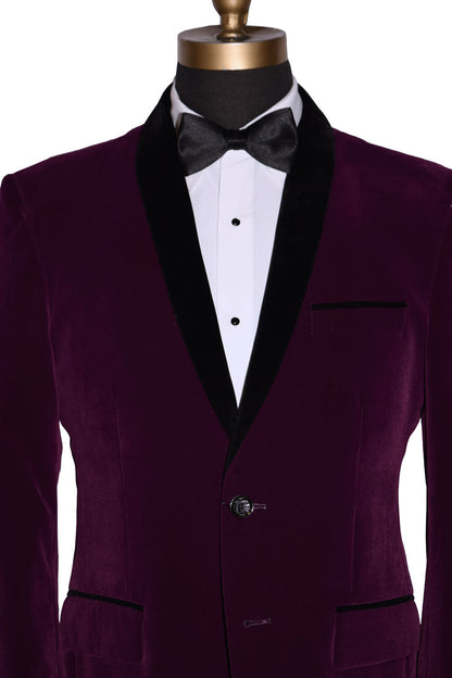Purple velvet tuxedo jacket with black lapels on a mannequin wearing a white tuxedo shirt and black satin bowtie against a white background