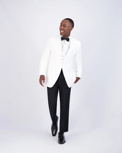 Man walking while wearing a white slim-fit notch lapel tuxedo with black pants and bow tie