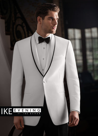 Man wearing a white shawl collar tuxedo with black trim on the lapel, standing against a dark background